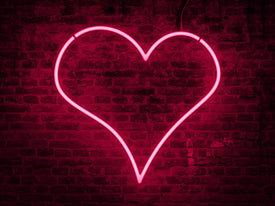 Valentine's Day Header Image. Black Brick Wall lit up with Neon Light Heart