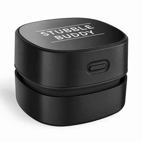 A black cylindrical product labeled 'STUBBLE BUDDY' on top, shown on a clean white background. The product has a matte black finish, a small side button, and a sliding lid.